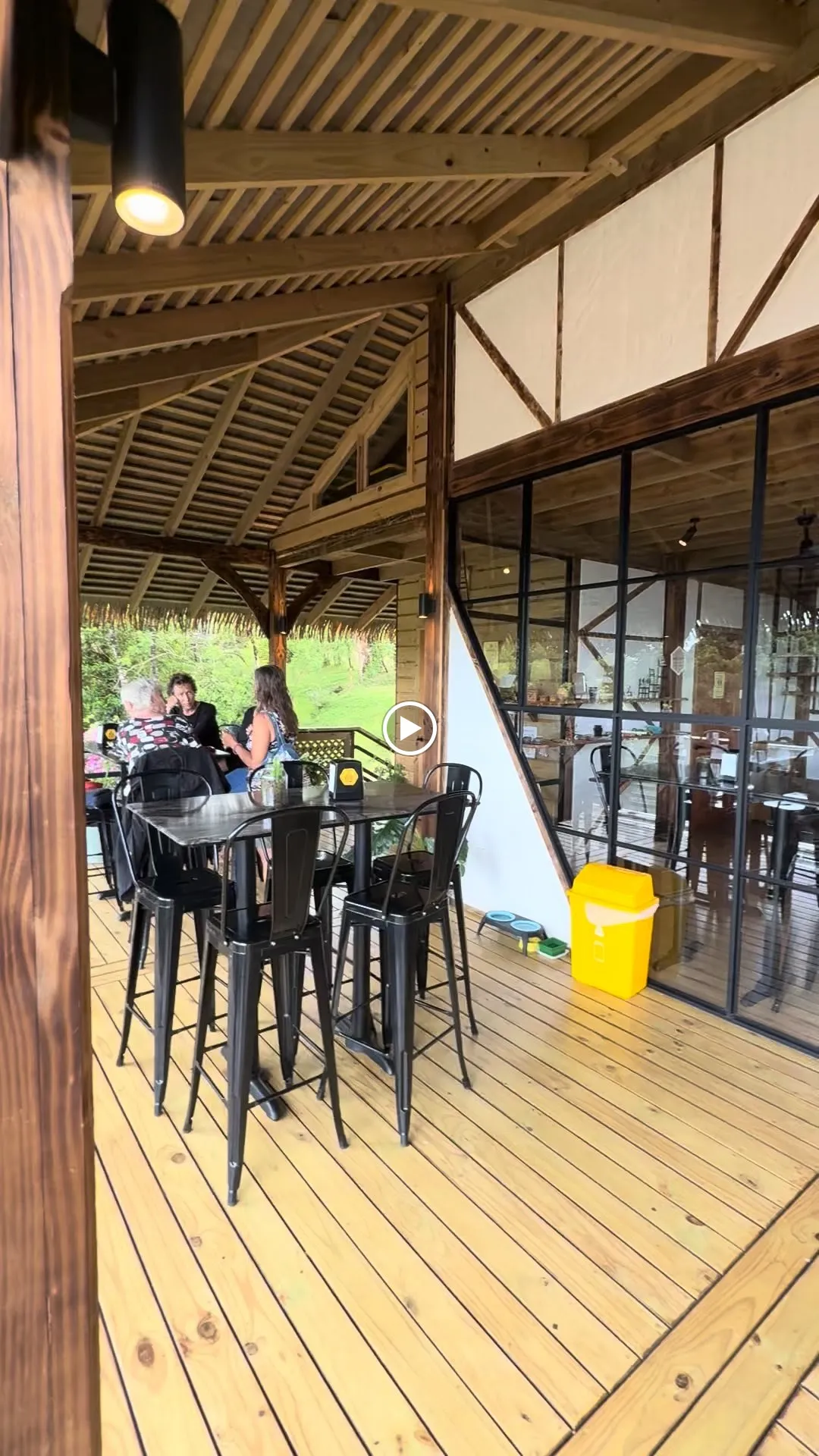 Guests at a picnic table on the café deck, jungle beyond